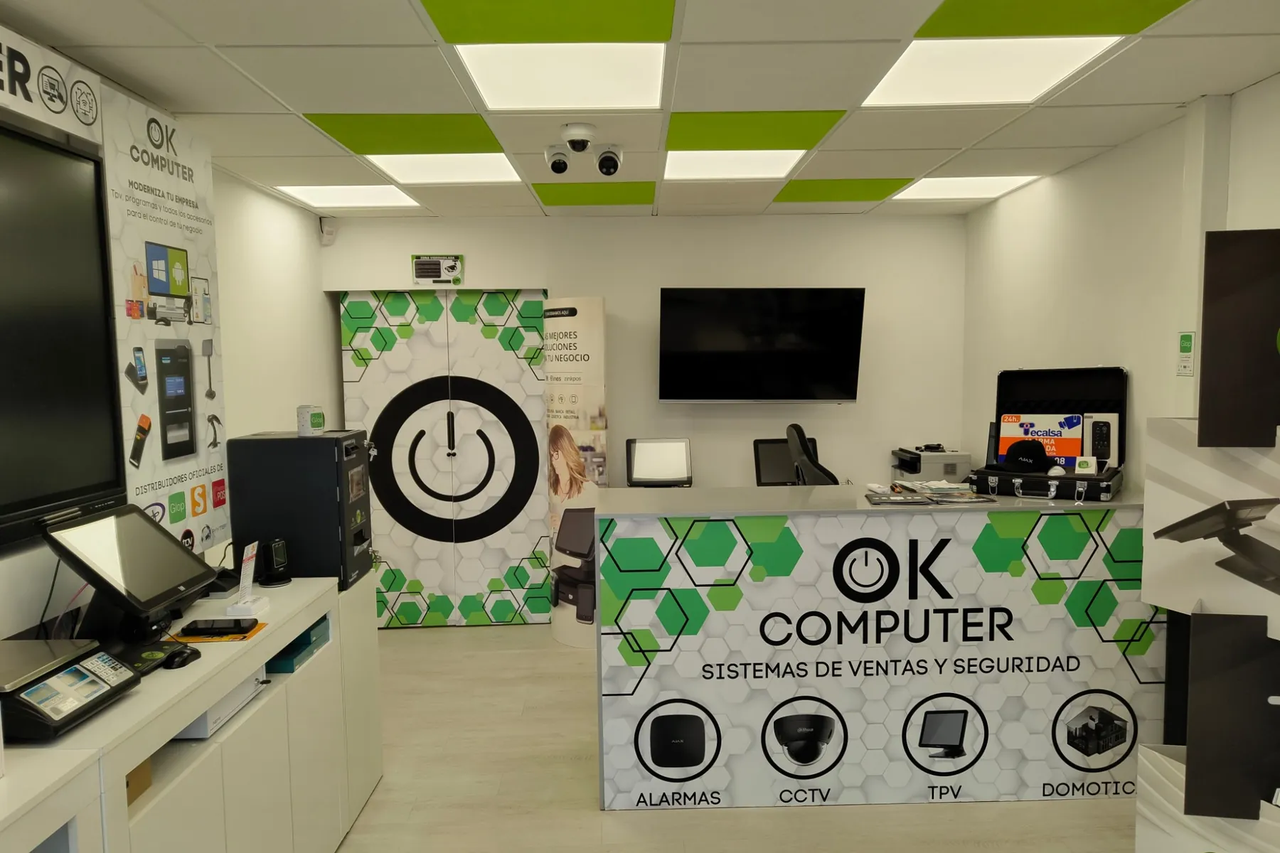 Inside the OK Computer shop in Armeñime: counter with the logo, POS on the left and cameras on the ceiling